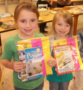 All students at Louise Luxford Elementary.like kindergartners Grace DeGrave, left,and Ava Anderson, recently chose free books to add to their home library.