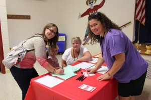 VIE Coordinator at North Landing Elementary School welcomes parent volunteer, Tricia Carter and daughter Tessa, now 4, to this year’s volunteer training. Volunteer Andrea Uhler was also on hand to welcome volunteers and explain the volunteer process at the school.