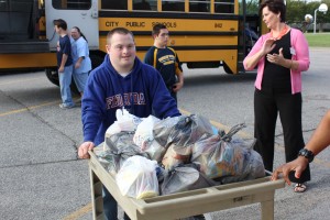 PAHS student Seth Markey helps to transport the Beach Bags from the bus into Pembroke Elementary where he was a former student. Beach Bags are discreetly placed in backpacks each Friday before students head home for the weekend. 