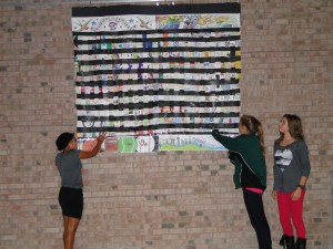 Ajeya Hawkins, Nicole Hoffmann and Hannah Sullivan showcase one of Virginia Beach Middle's weaving murals. 