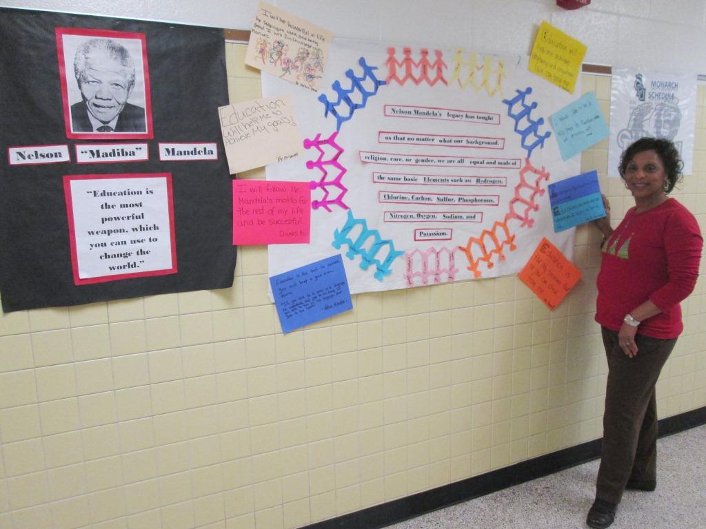 Eighth-grade science teacher Beverly Felder stands beside the tribute her students made for Nelson Mandela’s legacy.