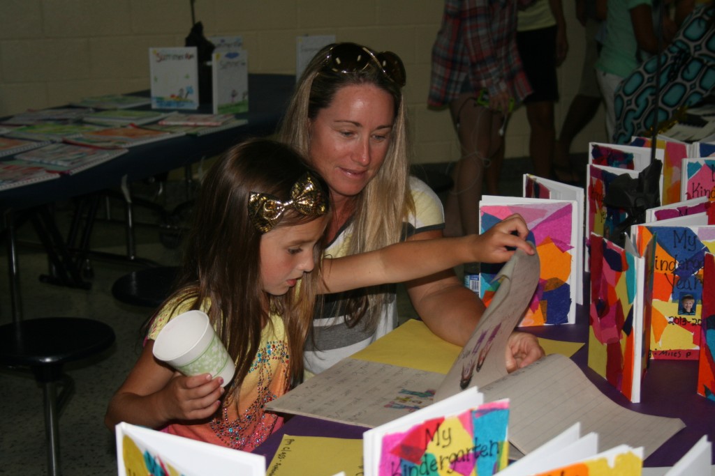 Kindergarten student Adelyn Rekant shows her mother her illustrated story.