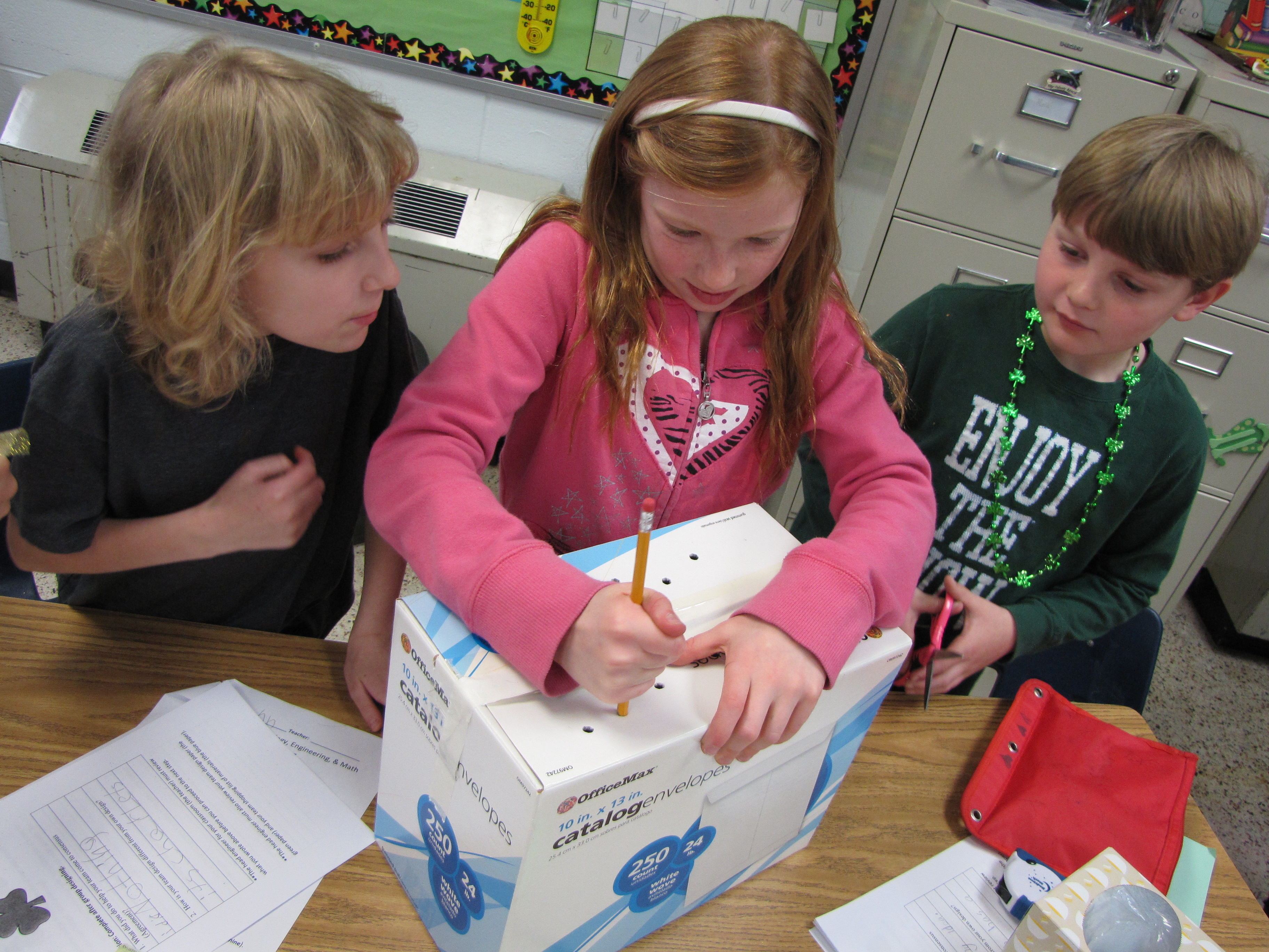 Third graders, Charlotte Bergren (center) and John Newell (left) with second-grader Tucker Rupe (right) work on their project. 