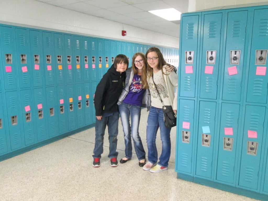 Billy Sager, Elizabeth Robinson and Maggie Minary stand in the seventh grade hall that they filled with inspirational messages.