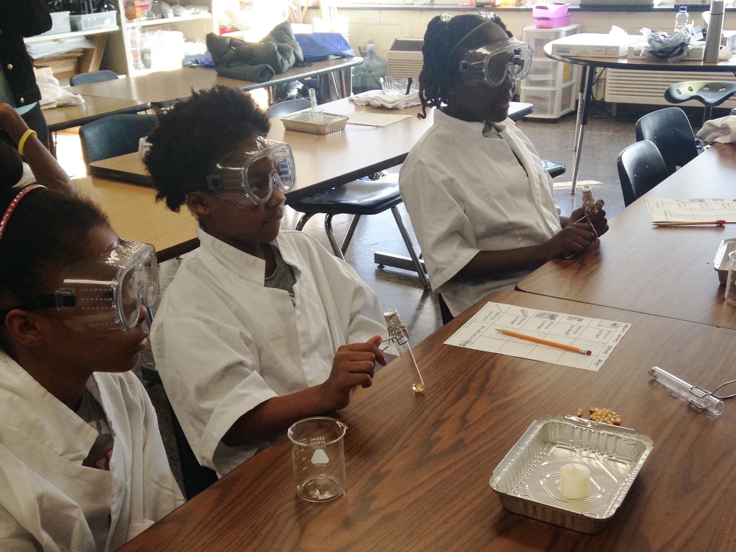 Students enjoyed the many hands on activities, here Lelani Neville, Taniyah Mathews, and Eniyah Stephens explore what happens in their experiment during the Saturday School popcorn lab. 