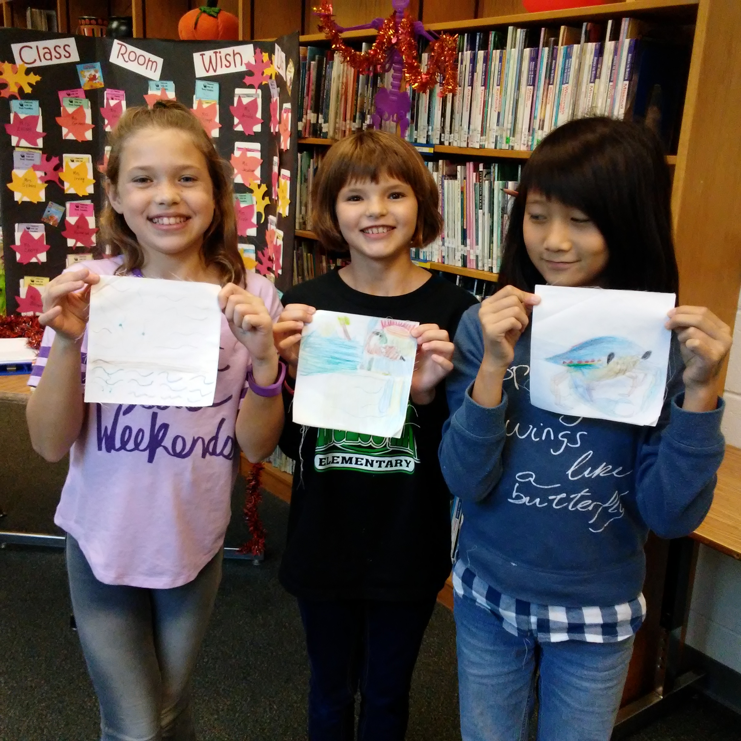Princess Anne Elementary fifth-graders Ella Morgan (left), Emmery Flanagan (center) and Jenny Chen (right) display the squares they created for the Lynnhaven River Now quilt project.