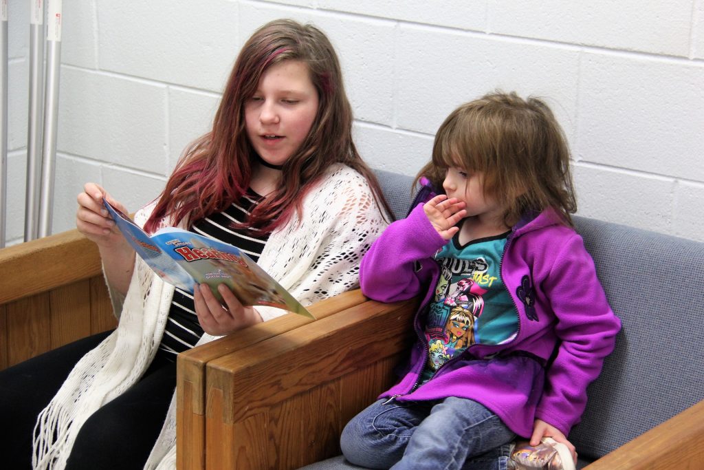 Older student reading to younger student
